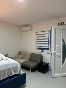 Un dormitorio con una cama y un sofá y una ventana. en Apartments Indigo, en Jajce