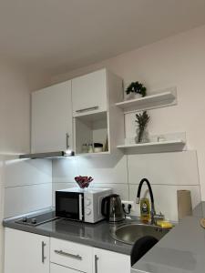 a kitchen with a microwave and a sink at Apartments Indigo in Jajce