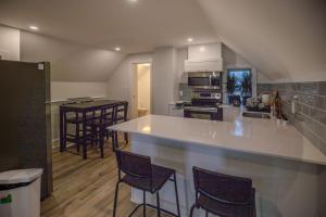 eine Küche mit einer weißen Theke und Stühlen in der Unterkunft One Bedroom Apartment - 3 Minutes from Downtown in Ottawa