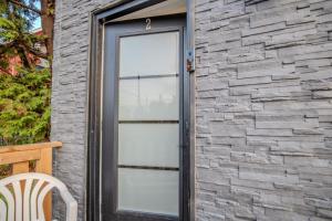 ein Steingebäude mit einer Tür und einem Stuhl in der Unterkunft One Bedroom Apartment - 3 Minutes from Downtown in Ottawa