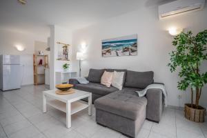 a living room with a couch and a table at Vila Rosa Flat in Portimão