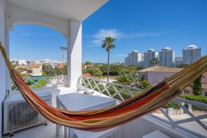 a hammock on a balcony with a view of the city at Vila Rosa Flat in Portimão
