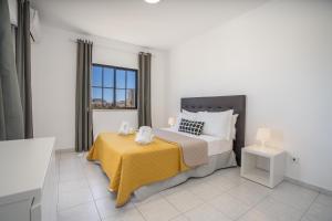 a bedroom with a bed with a yellow blanket at Vila Rosa Flat in Portimão +42 photos