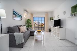 a living room with a couch and a table at Vila Rosa Flat in Portimão