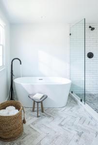 a white bathroom with a tub and a stool at The Coonamessett in Falmouth