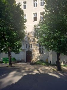 レグニツァにあるApartament Love on 5 - Miłość na 5の前に木々がある大きな白い建物