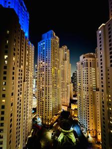 vistas a una ciudad por la noche con edificios altos en The Aero Vacation Homes en Dubái