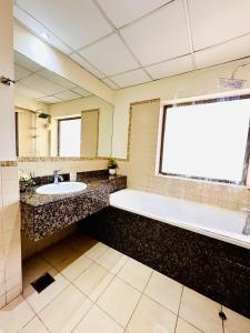 a large bathroom with a tub and a sink at The Aero Vacation Homes in Dubai