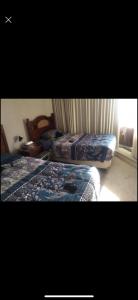 1 dormitorio con 2 camas y ventana en Departamento San alfonso del mar, en Algarrobo