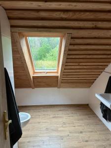 a bathroom with a wooden ceiling with a window at Penzion s rafty in Vyšší Brod