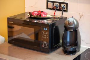a coffee maker next to a microwave on a counter at Malinowa Dolina in Wisła