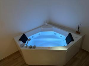 a jacuzzi tub in a room with a blue light at Maison Costa Masciarelli in LʼAquila