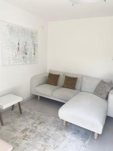 a white living room with a couch and a table at Appartement Tara in Malinska