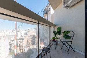 een balkon met stoelen en uitzicht op de stad bij Fliphaus Venezuela 900 B - Loft San Telmo in Buenos Aires