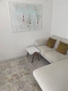 a white living room with a couch and a table at Appartement Tara in Malinska