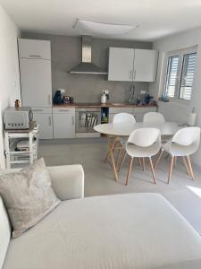 a living room with a couch and a table and chairs at Appartement Tara in Malinska