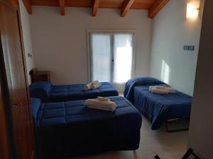 2 camas en una habitación con sábanas azules en La collinetta B&B, en Crespellano