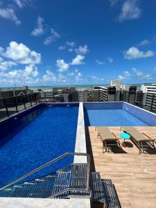 a swimming pool on the roof of a building at Melhores Flats - Tranquilo, pertinho do mar in João Pessoa