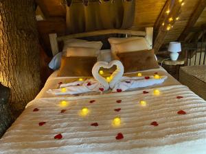 Un dormitorio con una cama con un corazón hecho de velas en Cabane suspendue dans les arbres, en Villebon-sur-Yvette