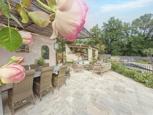 un patio avec une table, des chaises et des fleurs dans l'établissement Villa Céladon Valbonne - Piscine, à Valbonne