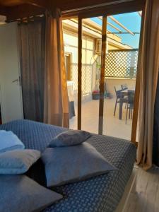 Cama con almohadas en habitación con balcón en Casa Paradiso en Lido di Ostia