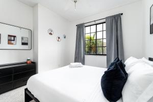 a white bedroom with a bed and a window at Newly Remodeled Lakefront Oasis in Delray Beach +24 photos