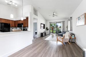 an open living room and kitchen with white walls and wood floors at Newly Remodeled Lakefront Oasis in Delray Beach