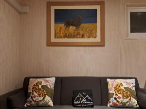 a couch with two pillows and a picture of a camel at Casa Pumahue in La Ensenada