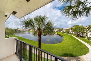 a view of a lake from a balcony with a palm tree at Newly Remodeled Lakefront Oasis in Delray Beach