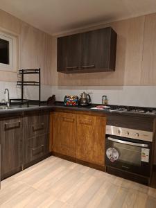 a kitchen with wooden cabinets and a stove top oven at Casa Pumahue in La Ensenada