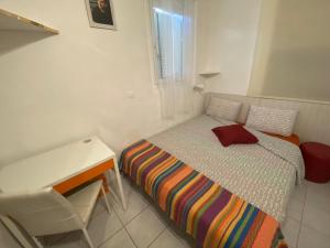 カンヌにあるCannes Privat Residence Holiday Apartmentsの白い小さなベッドルーム(ベッド1台、デスク付)