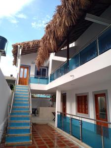 a house with a staircase and a straw roof at HABITACIONES EN casa de playa in Coveñas