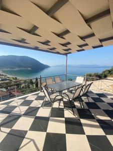 eine Terrasse mit einem Tisch und Stühlen auf einem karierten Boden in der Unterkunft Christie's Panorama in Póndi