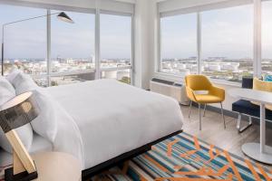 a bedroom with a bed and a table and chairs at Aloft Fort Lauderdale Airport in Fort Lauderdale