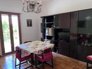 a dining room with a table and a television at Montefortino Sibillini House in Montefortino