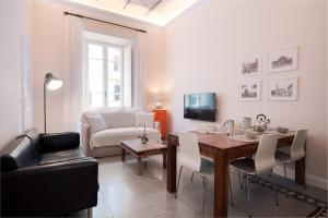 a living room with a dining room table and a couch at Quirino Visconti Apartment Prati in Rome