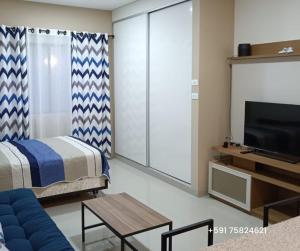 a living room with a bed and a tv at Departamento Express CL in Vila El Carmen