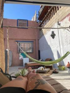 a person laying on a hammock in a house at Vibe Surf Morocco in Agadir