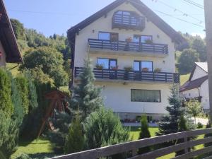 a house with a balcony with potted plants on it at VILA ALICE & DENIS in Bran