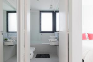 Baño blanco con 2 lavabos y aseo en Fliphaus Zapiola 2300 'e' - 1 Bd Belgrano en Buenos Aires