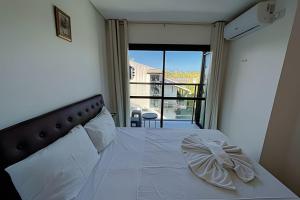 ein Schlafzimmer mit einem weißen Bett und einem Balkon in der Unterkunft Flat Kandela - Maracaípe in Porto De Galinhas + 23 Fotos