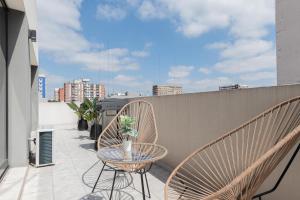 un patio con 2 sillas y una mesa en el balcón en Fliphaus Zapiola 2300 'e' - 1 Bd Belgrano en Buenos Aires