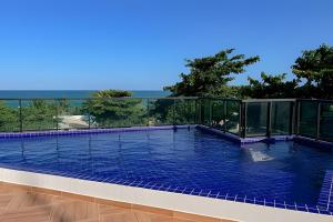 a swimming pool with a view of the ocean at Flat Kandela - Maracaípe in Porto De Galinhas