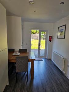 una sala da pranzo con un tavolo di legno e un tavolo da pranzo di 5 Fulmar Road**Next to West Beach and Golf Course a Lossiemouth