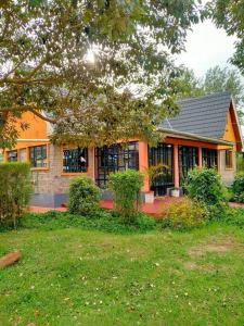 an orange house with a yard in front of it at The Orange Cottage in Nyeri