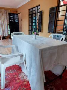 a white table with white chairs and a white table cloth at The Orange Cottage in Nyeri