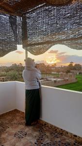 a woman hugging a man against a wall looking at the sunset at Dream Garden Luxor in Luxor