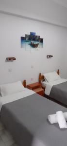 a bedroom with two beds and a painting on the wall at Hermes in Kavos