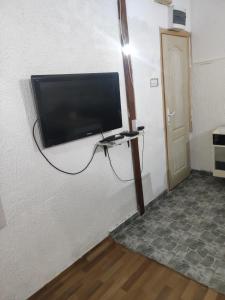einen Flachbild-TV, der an einer Wand hängt in der Unterkunft Prenoćište Inđija Hrvić in Inđija