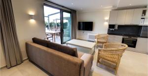 a living room with a couch and a kitchen at Mitos Villas in Gerani